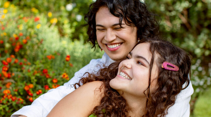 Two LGBTQ young people embracing and smiling