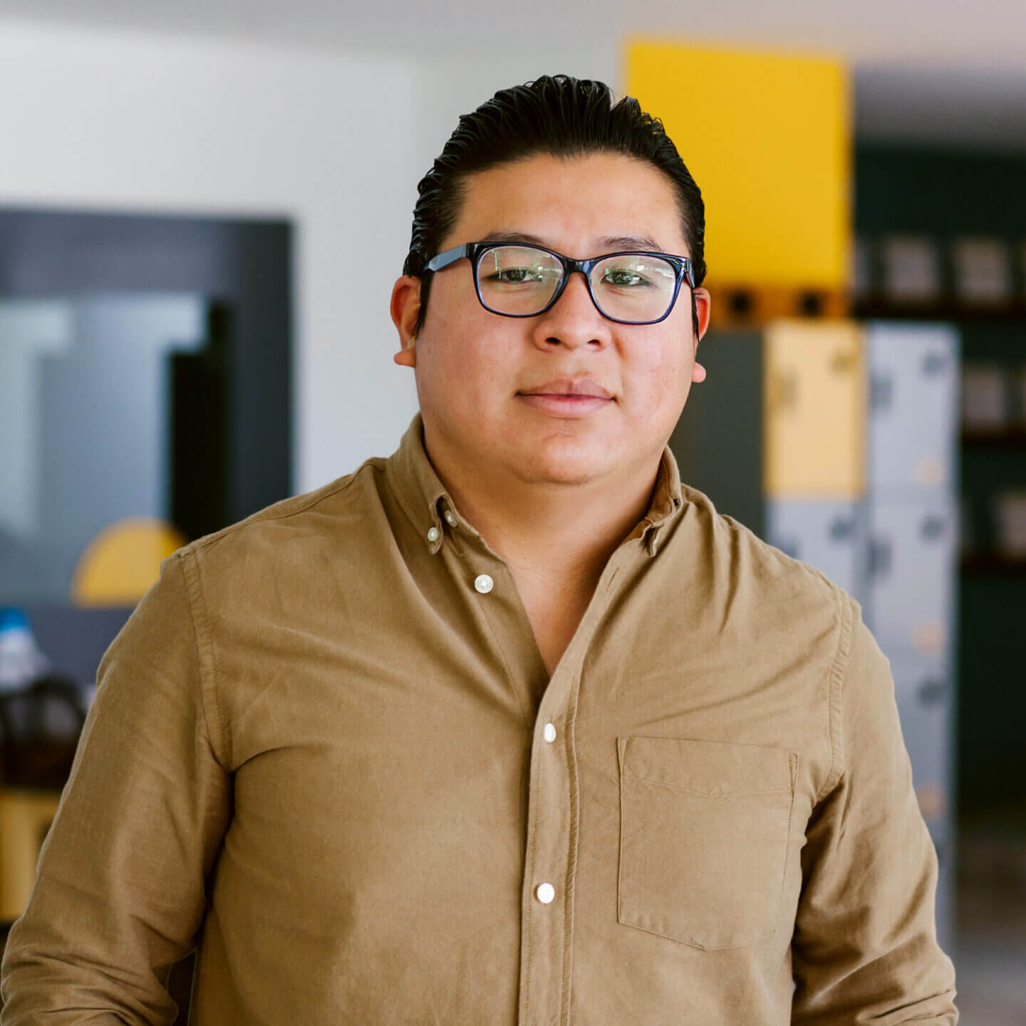 Portrait of a person wearing a green shirt with a look of satisfaction.