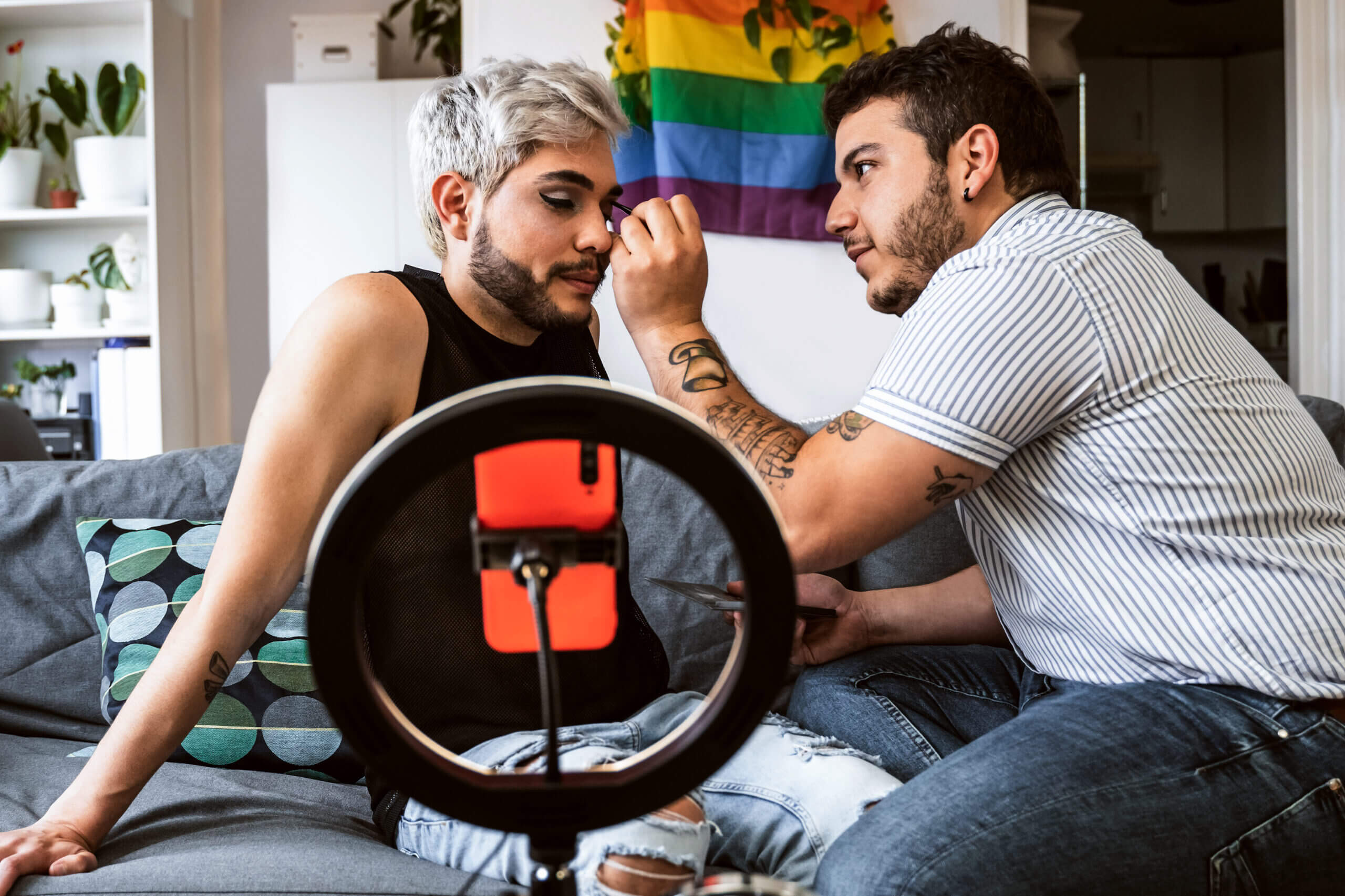 Person helping another person with makeup before doing a livestream on social media.