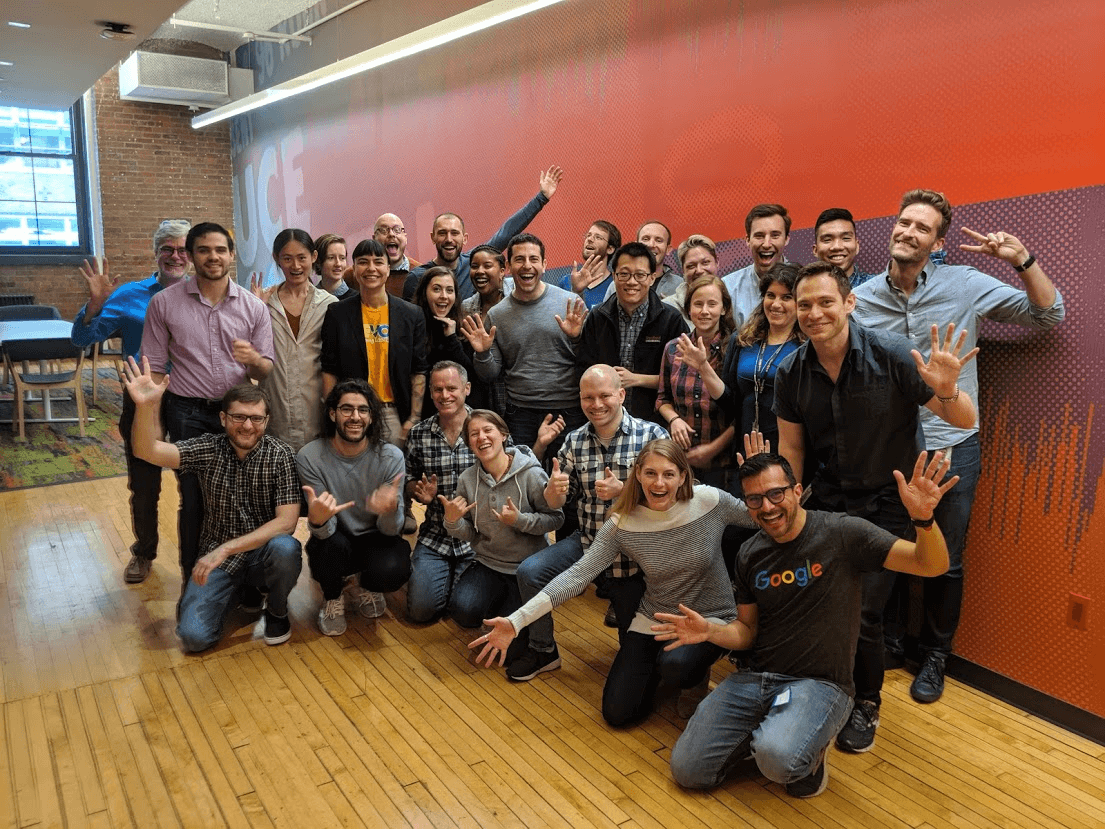 A group photo of Trevor and Google employees smiling in the office.