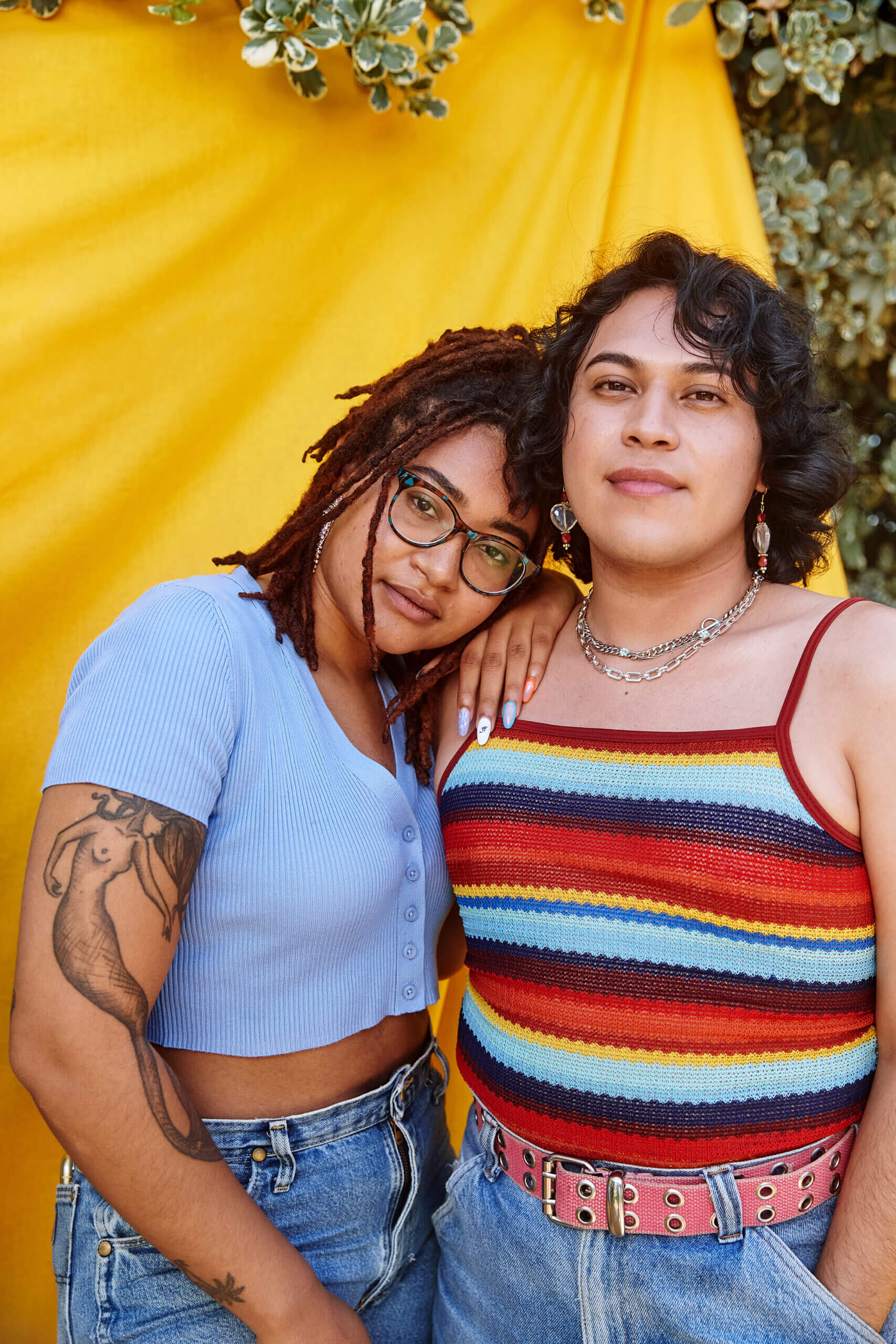 Two young people standing in front of a yellow backdrop