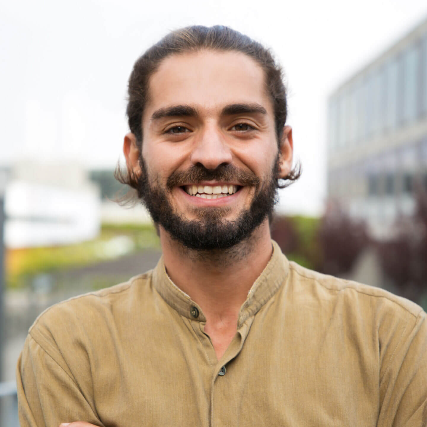 A person outside on a sunny day smiling.