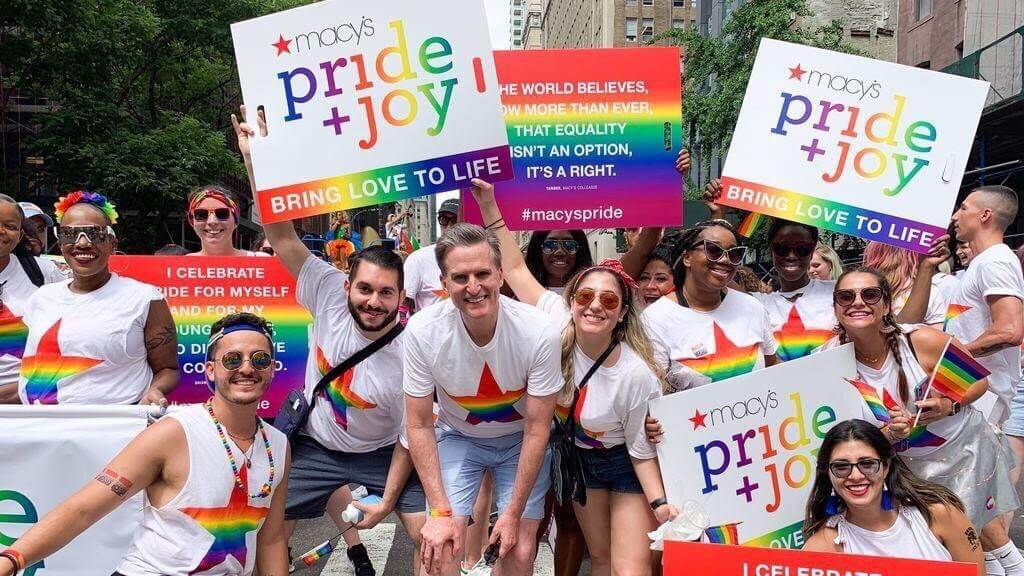 A crowd of people at a pride parade celebrating in the street.