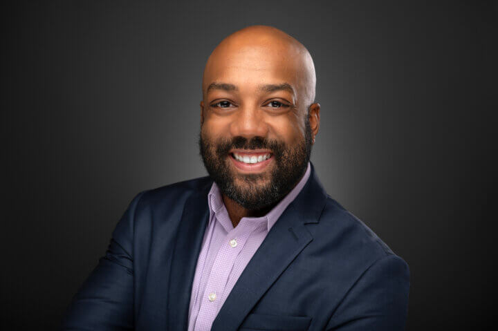 A headshot of a smiling Dr. Derrick Matthews (he/him)