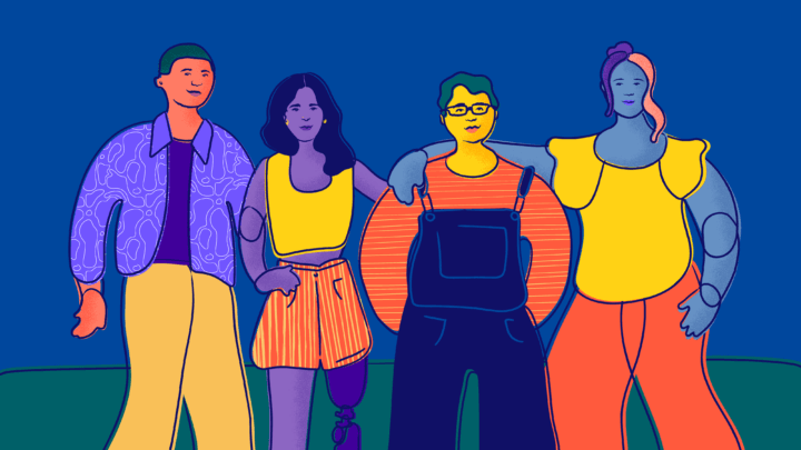 Four young people stand and smile.